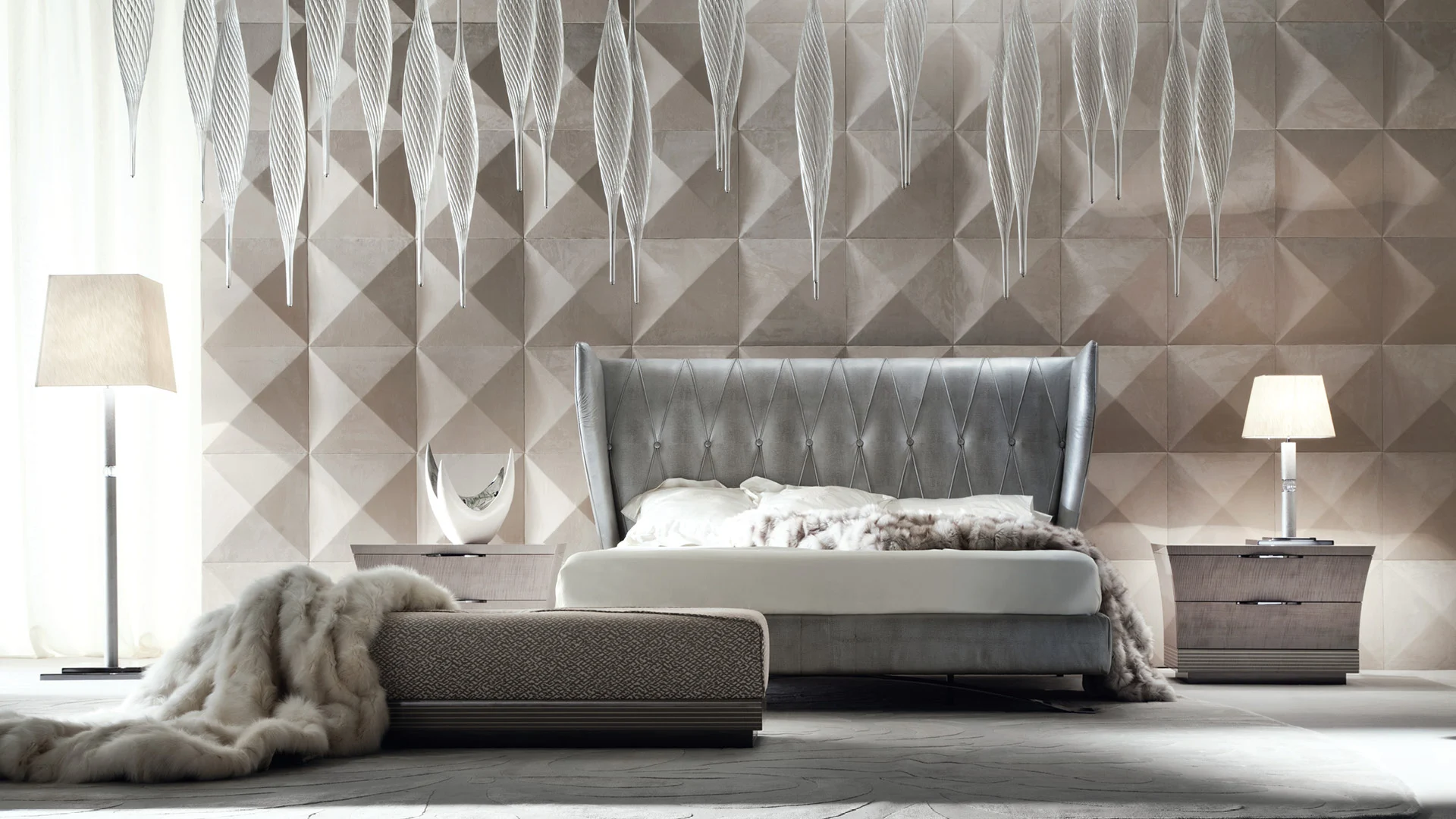 A grey upholstered bed with coordinated bedside tables and a bench.
